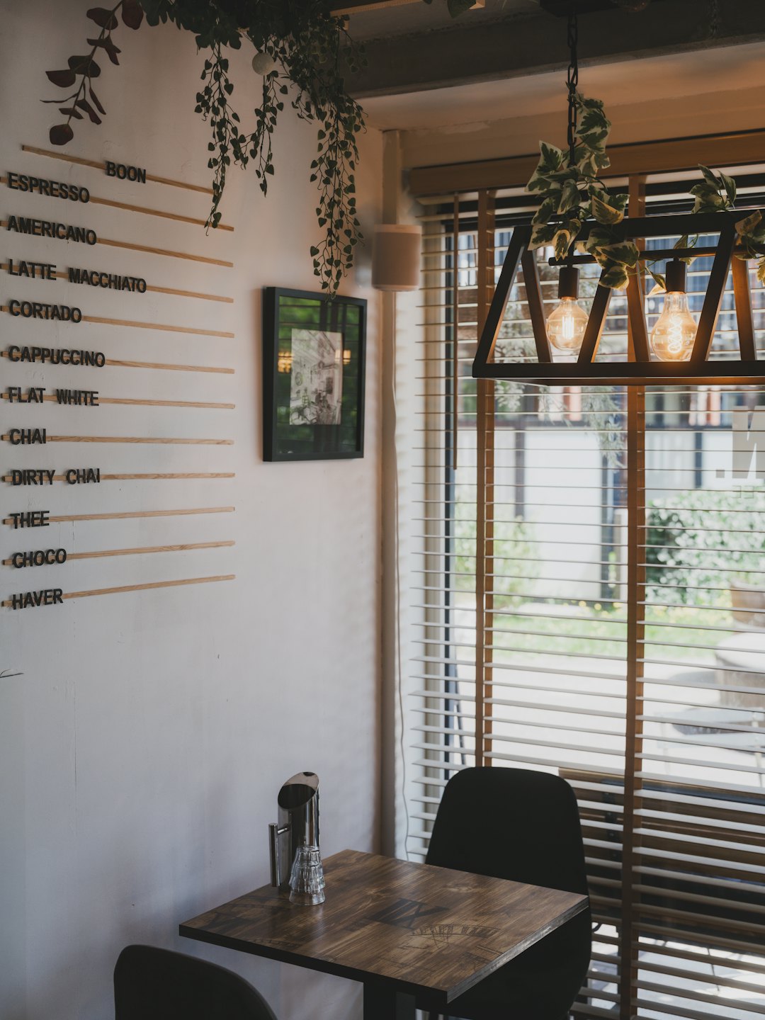 Wooden table and menu board inside a rustic coffee shop.